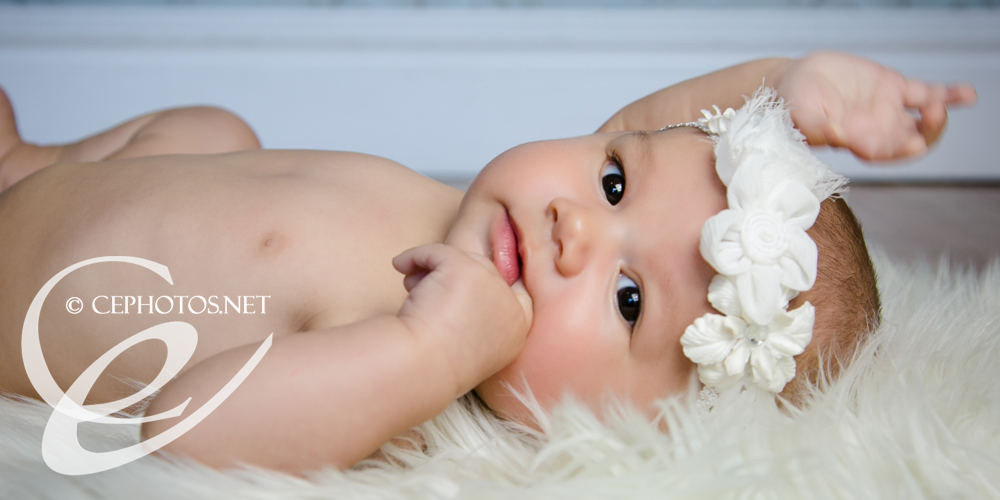 newborn baby girl in white flowered headband denver baby photographer