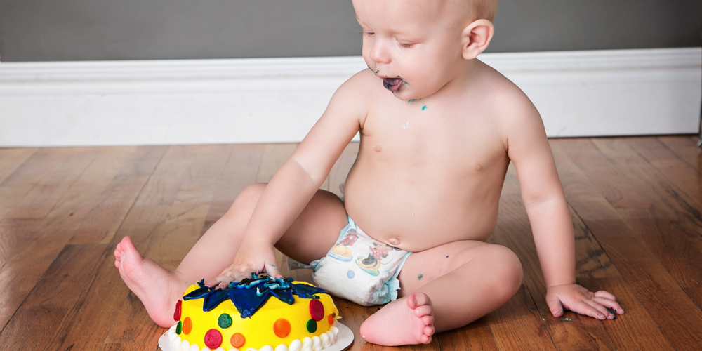 Photo of baby boy with first birthday cake